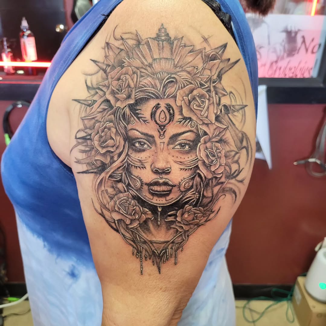 Black and grey ornamental woman with roses tattoo on shoulder