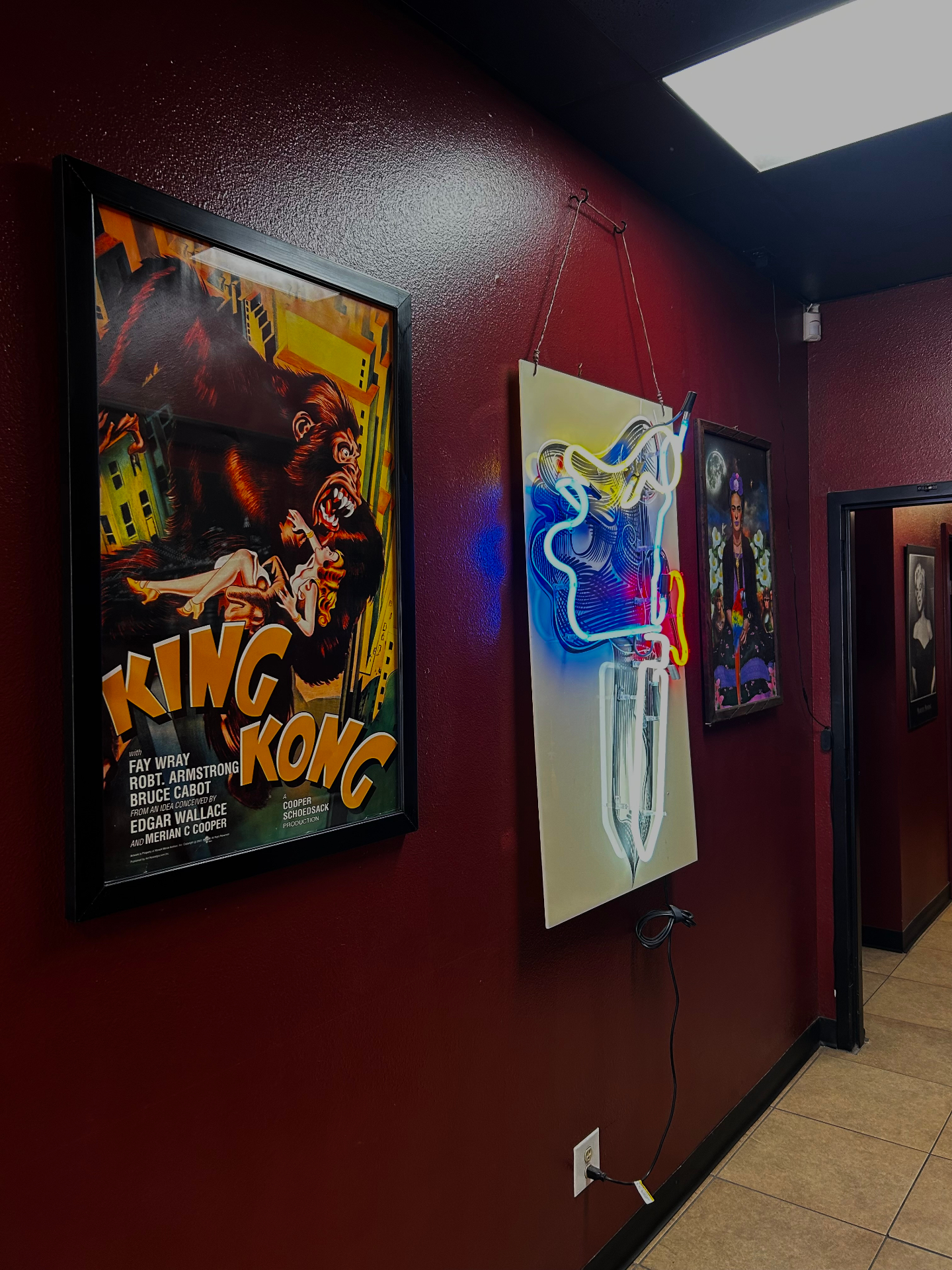 Framed art and neon piece in the Valley Tattoo studio